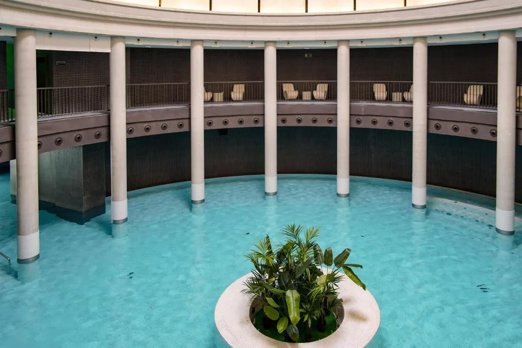 Piscina termal circular bajo una cúpula con columnas