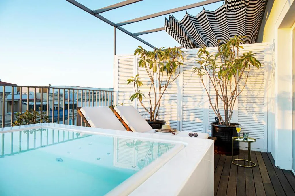Terraza privada con bañera exterior, tumbonas y vistas a los tejados
