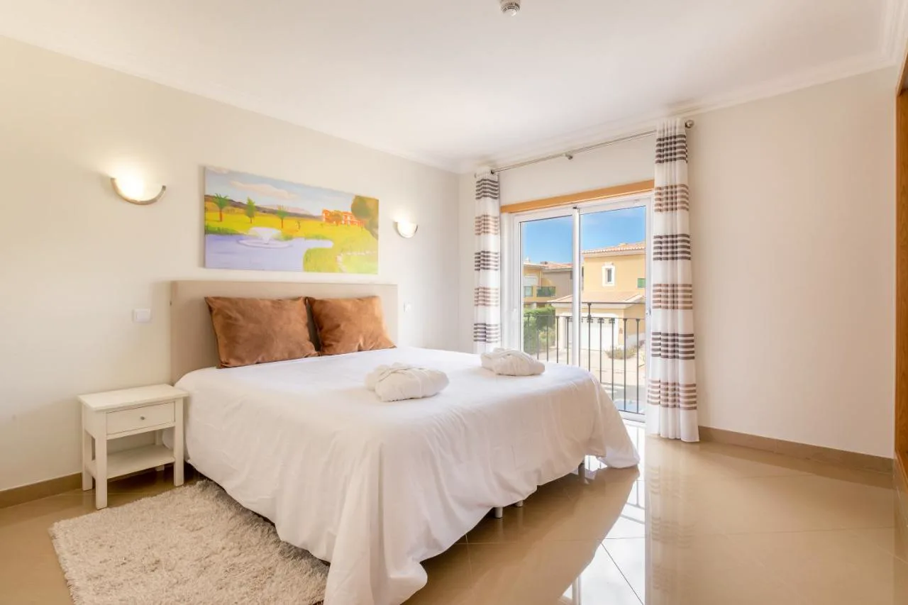 Dormitorio con balcón en un apartamento de Boavista Golf & Spa