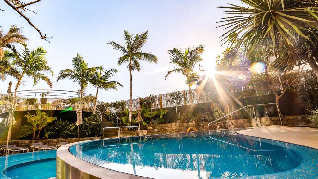 Piscina exterior al atardecer entre palmeras, Bohemia Suites Playa del Inglés