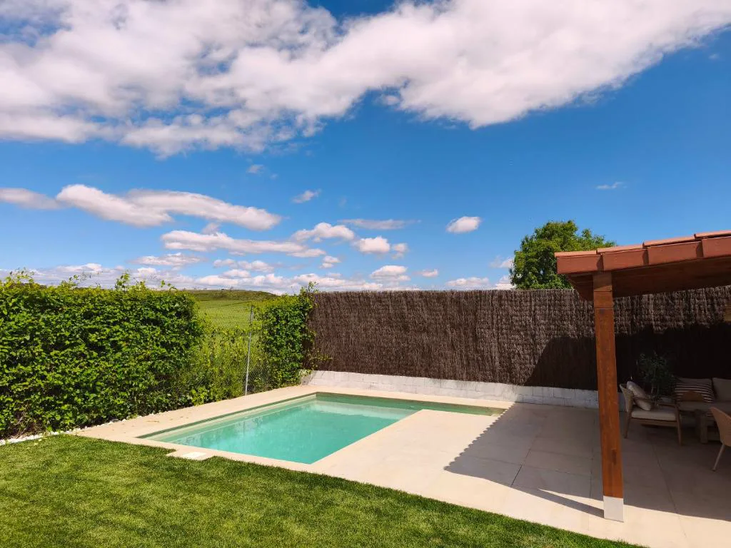 Piscina pequeña con pérgola y jardín de césped