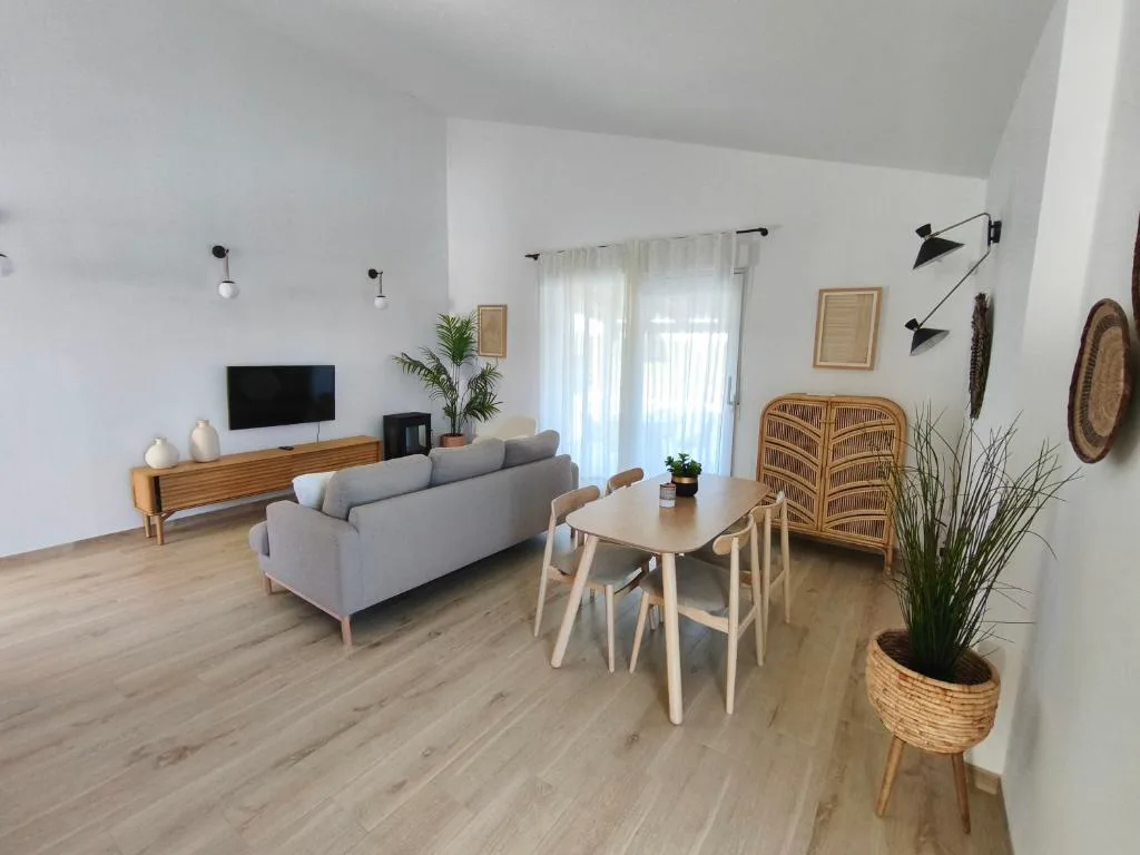 Salón claro con sofá gris y comedor