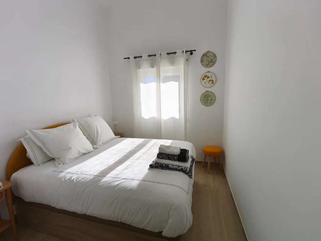 Dormitorio blanco con cama doble y ventana
