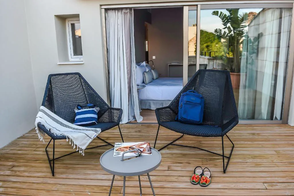 Terraza privada con sillones de mimbre y vistas a los tejados de Mahón, Bordoy Casa Ládico