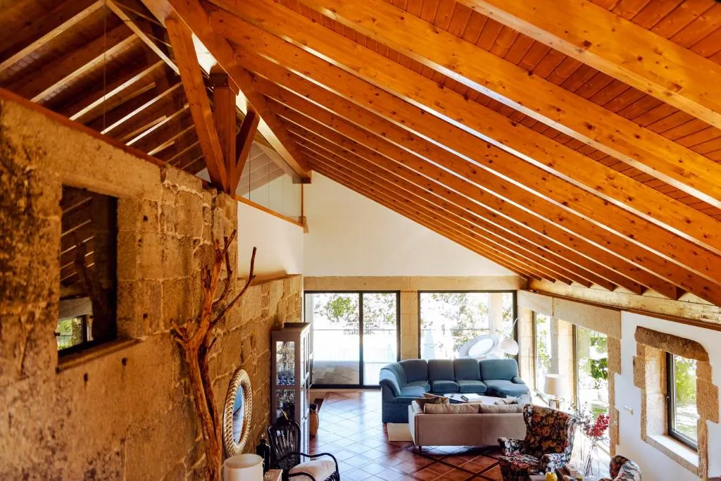 Salón con techo de madera a dos aguas y sofás en Bosque de Xarás, Marín