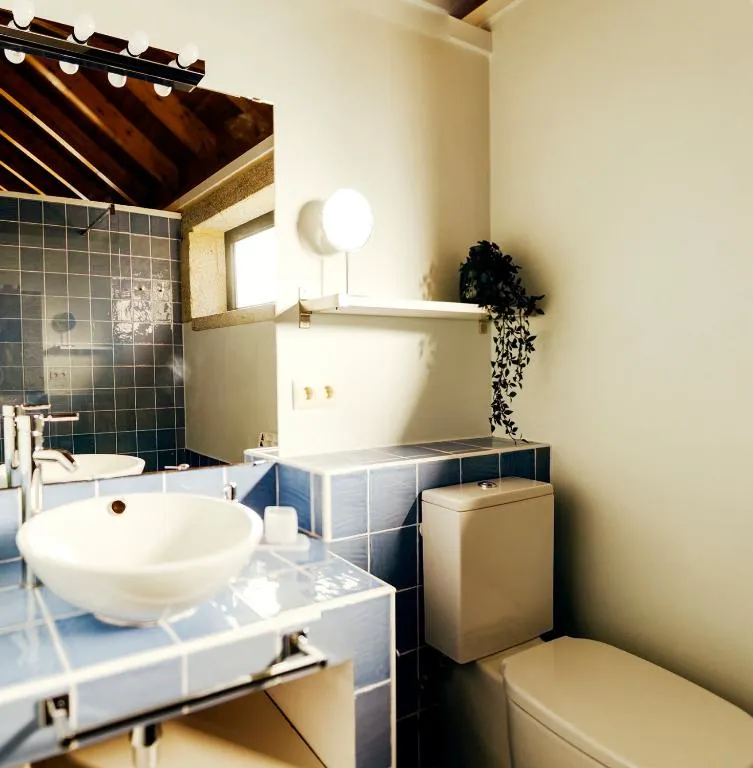 Baño con azulejo azul y lavabo blanco en Bosque de Xarás, Marín