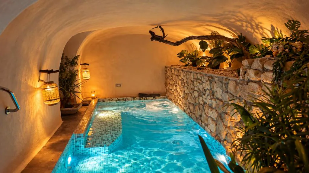 Piscina interior en una cueva de piedra con luz cálida