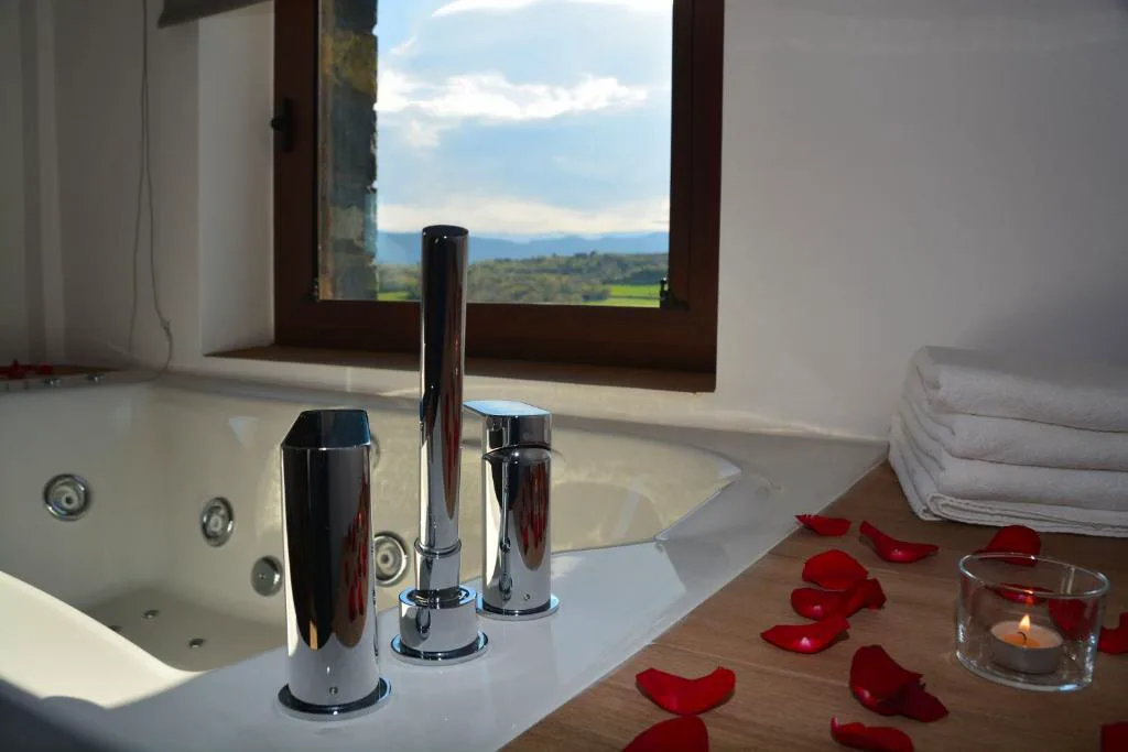 Bañera de hidromasaje con pétalos de rosa y velas