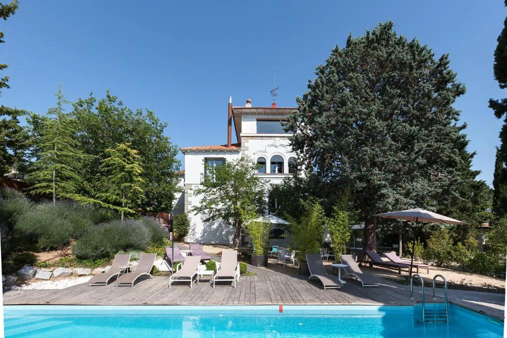 Piscina con tarima y jardín junto a la mansión