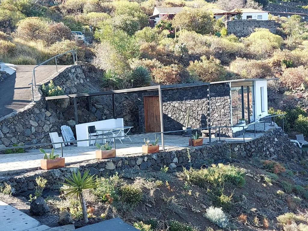 Bungalow de piedra volcánica y cristal integrado en una ladera con jardín en terrazas, Bungalowmirador