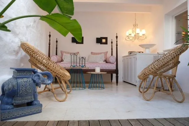 Patio interior con sillones de ratán, elefante de cerámica azul y planta de hojas grandes, Ca na Kika, Es Migjorn Gran, Menorca