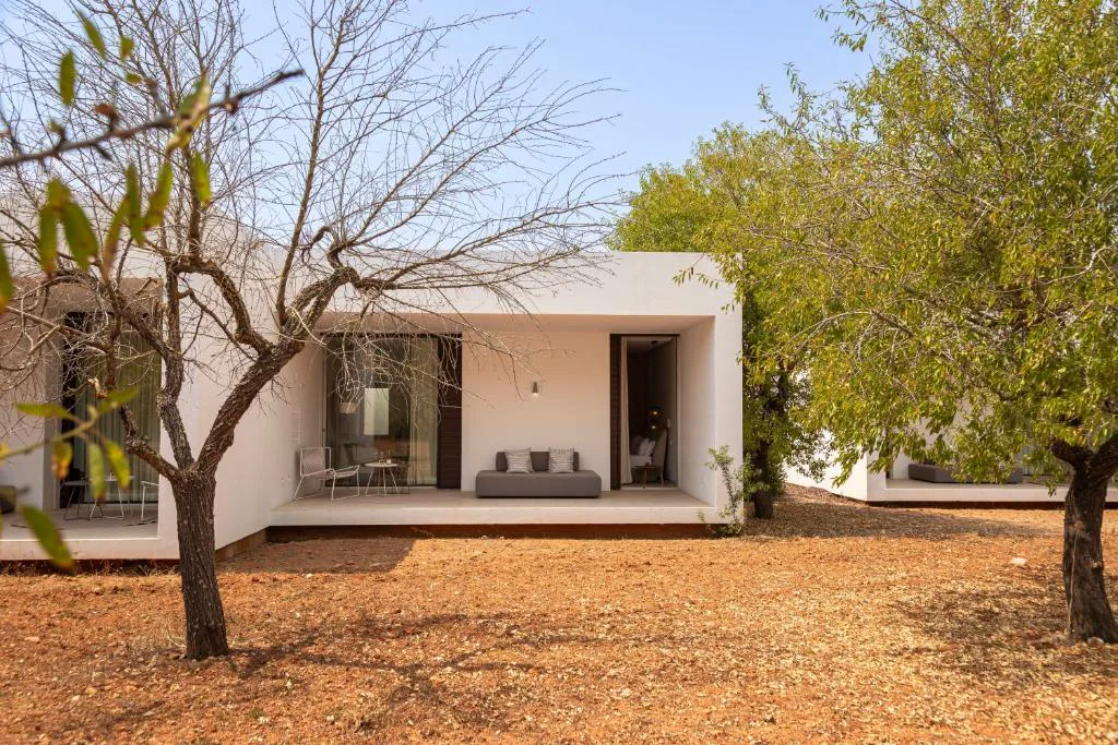 Bungaló blanco de arquitectura minimalista entre almendros, Ca Na Xica