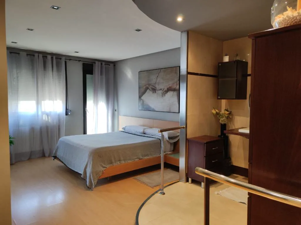 Habitación con cama y ventanal con persianas