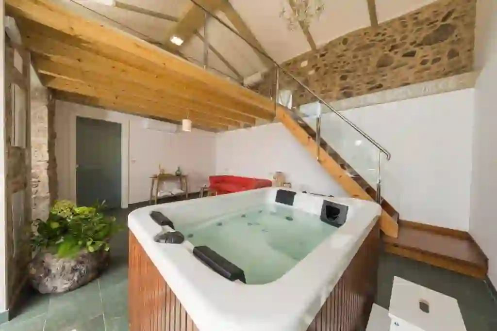 Jacuzzi de hidromasaje junto a la escalera de madera y piedra, Cabaña de Nemiña