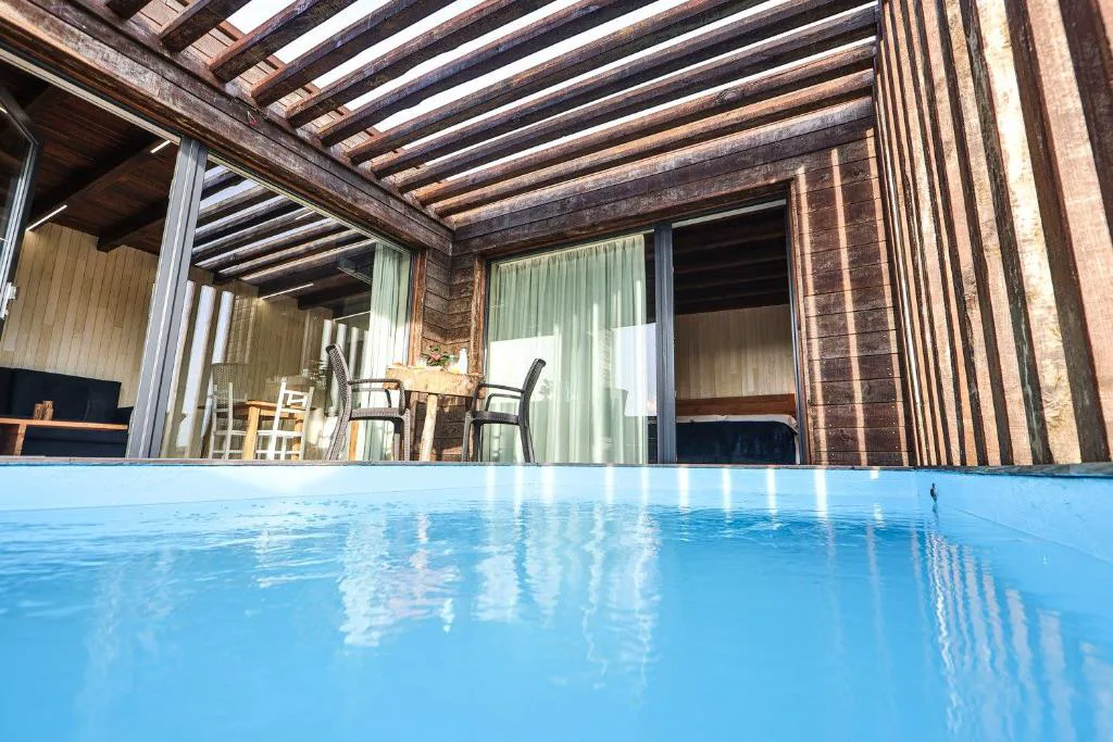 Piscina privada junto a la cabaña de madera con terraza cubierta, Cabañas de Mallas