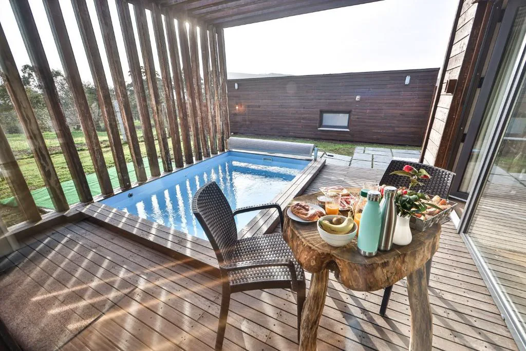 Piscina privada con mesa de desayuno preparada bajo el porche de madera, Cabañas de Mallas