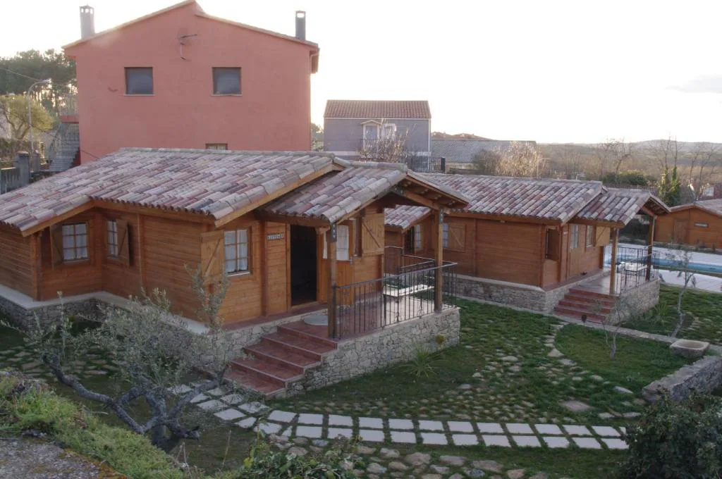 Conjunto de cabañas de madera con tejado de teja y jardín