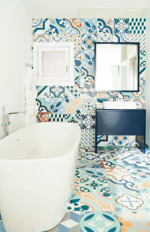 Baño con azulejos de mosaico multicolor y bañera exenta, CalaLanzarote Suites Hotel