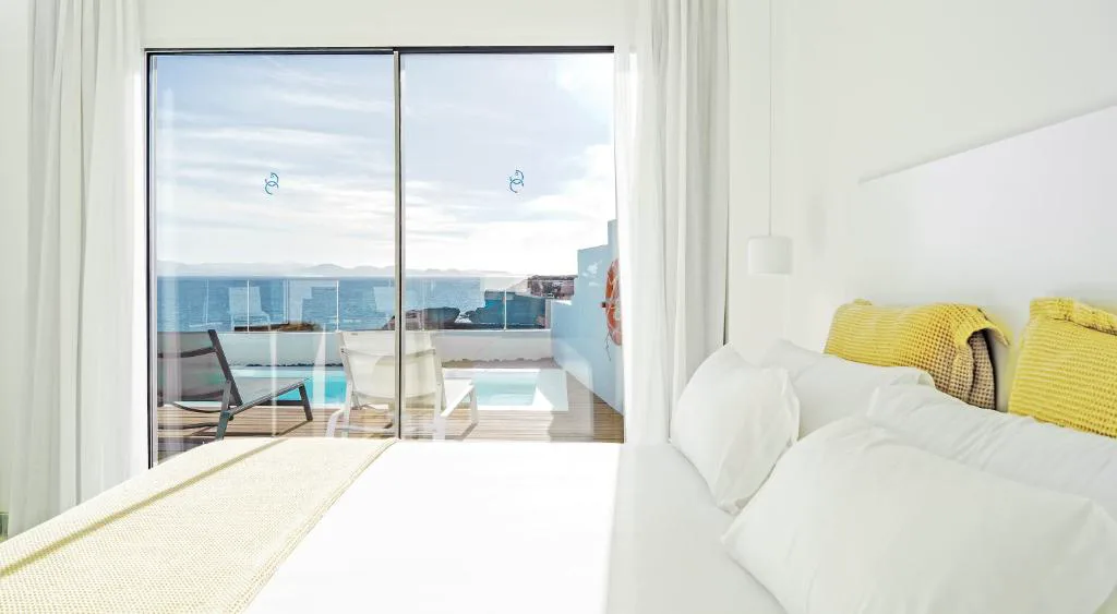 Dormitorio con vistas al mar y piscina privada en la terraza, CalaLanzarote Suites Hotel