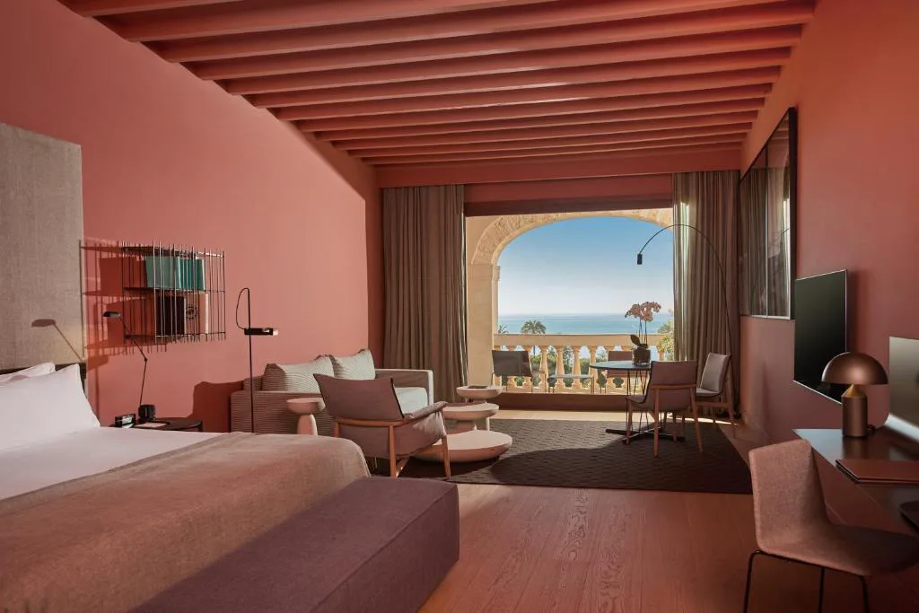 Dormitorio en tonos terracota con arco y vistas al mar, Calatrava Hotel