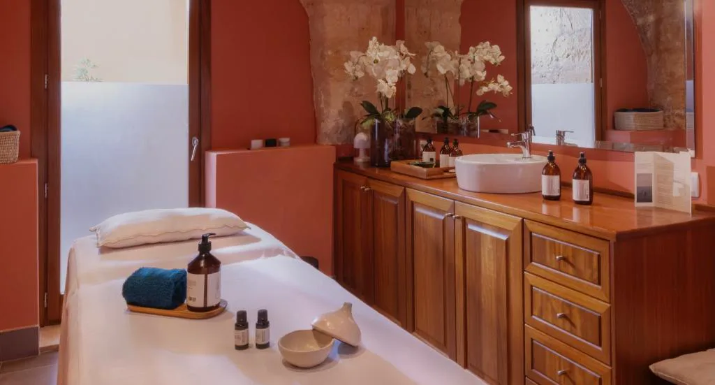 Sala de tratamientos del spa con orquídeas y productos de bienestar, Calatrava Hotel