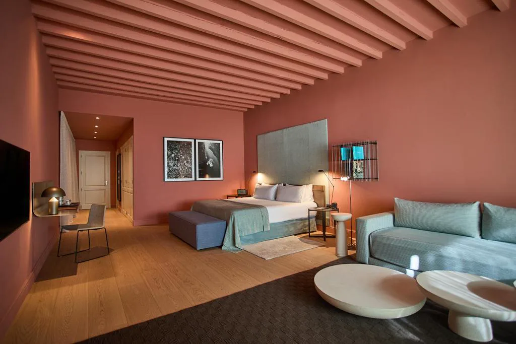Dormitorio con sofás verdes y puertas balconeras abiertas al Mediterráneo, Calatrava Hotel