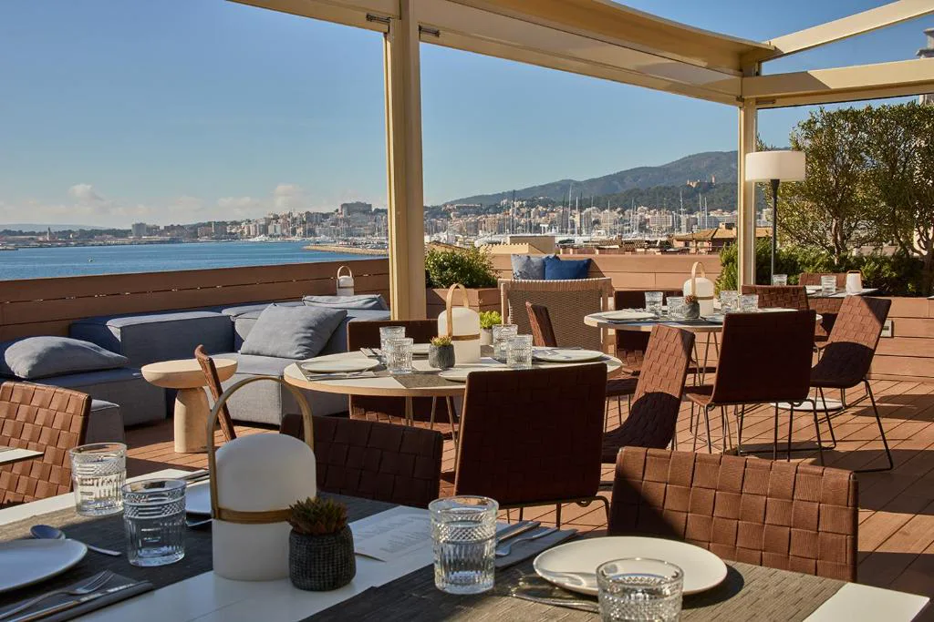 Terraza en la azotea con mesas puestas y vistas a la bahía de Palma, Calatrava Hotel