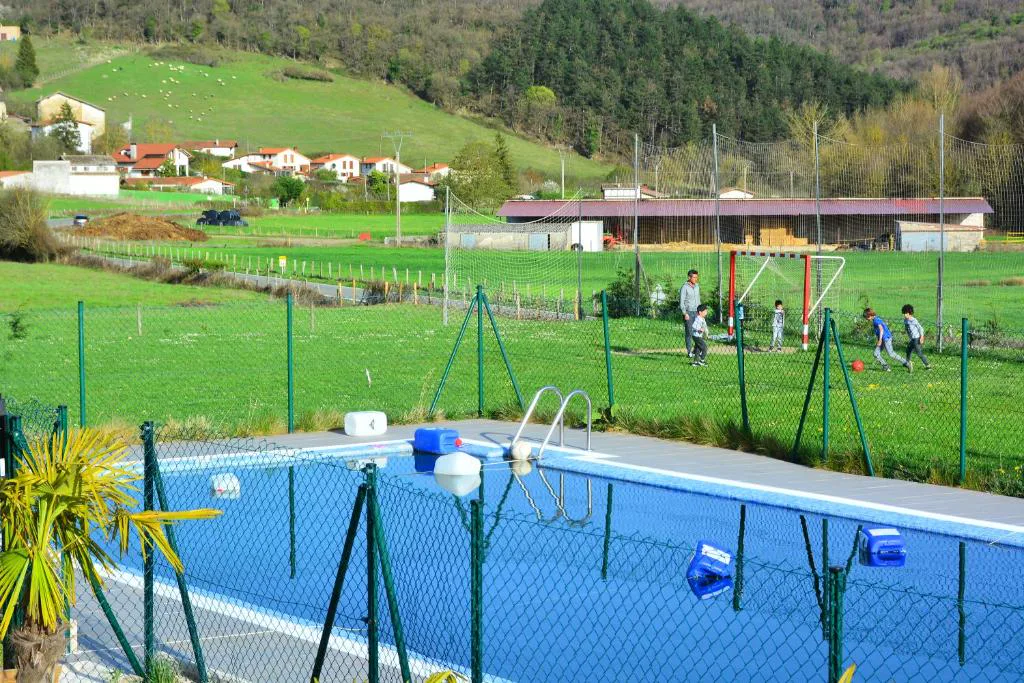 Piscina azul junto a una pista deportiva