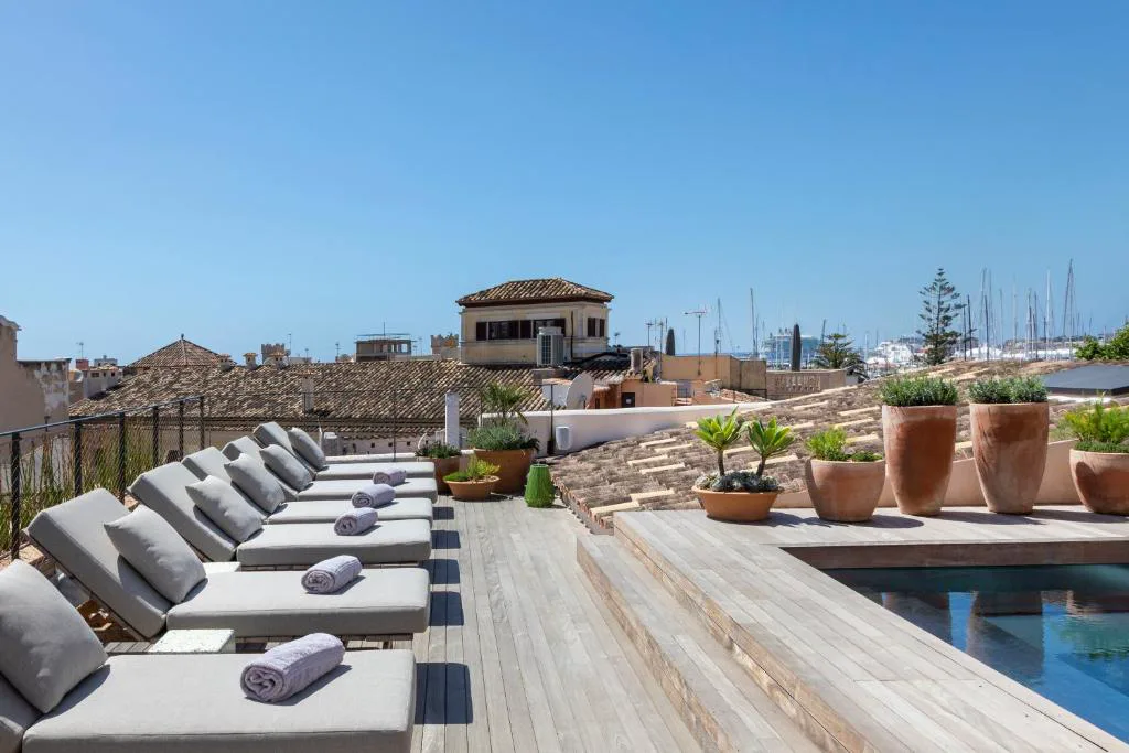 Tumbonas en la azotea con vistas a los tejados y al puerto de Palma, Can Bordoy Grand House