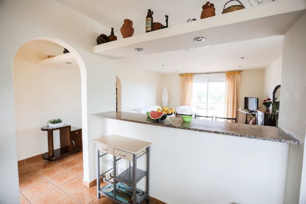 Cocina abierta con encimera de granito y vasijas de barro tradicionales, Can Furnet