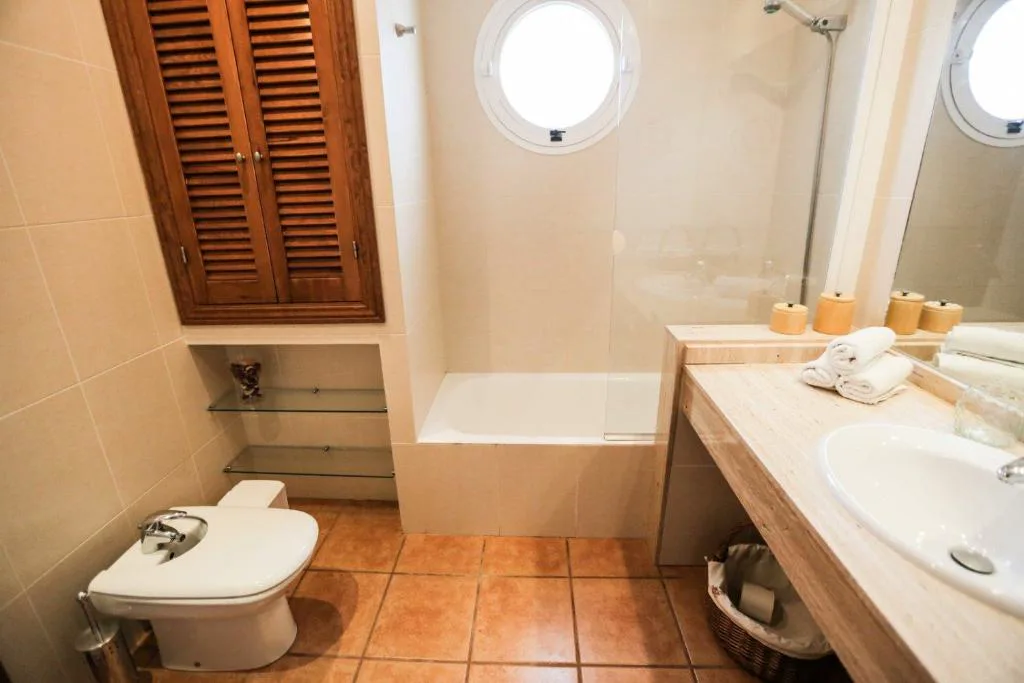 Baño con ventana circular tipo ojo de buey y bañera, Can Furnet