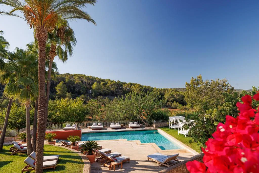 Piscina exterior entre palmeras y buganvillas en Can Lluc Boutique Country Hotel & Villas, Sant Rafel, Ibiza