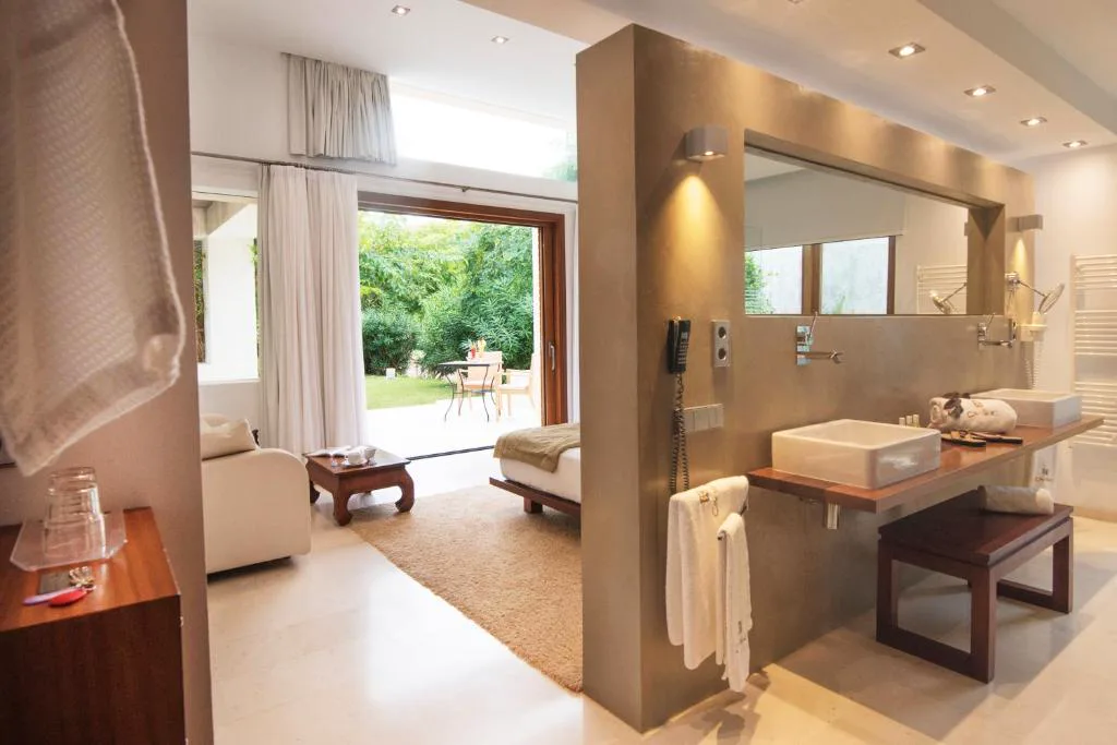 Baño con doble lavabo de piedra y vistas al jardín, Can Lluc