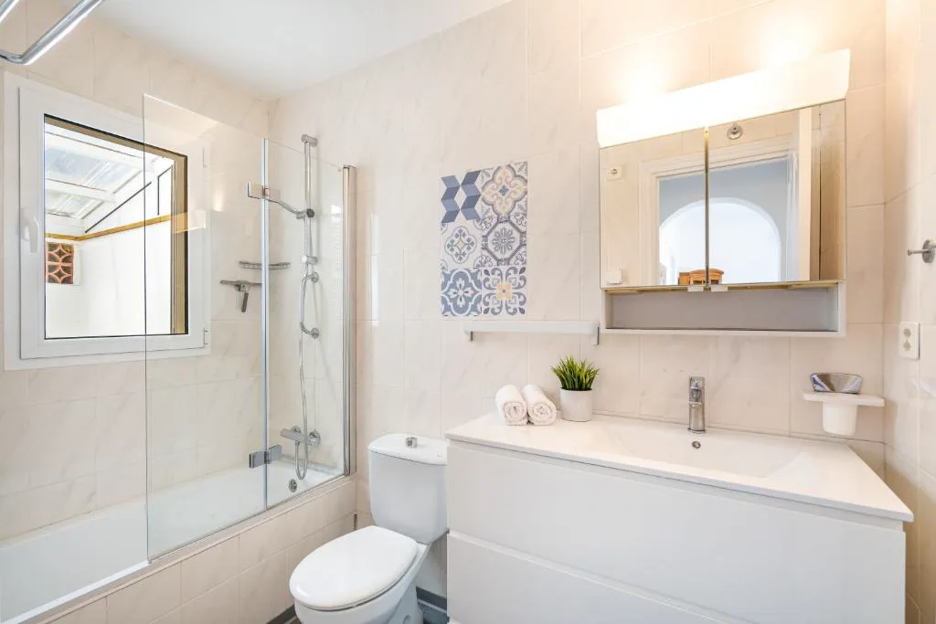 Baño moderno con azulejos de mosaico geométrico azul, Can Poriol
