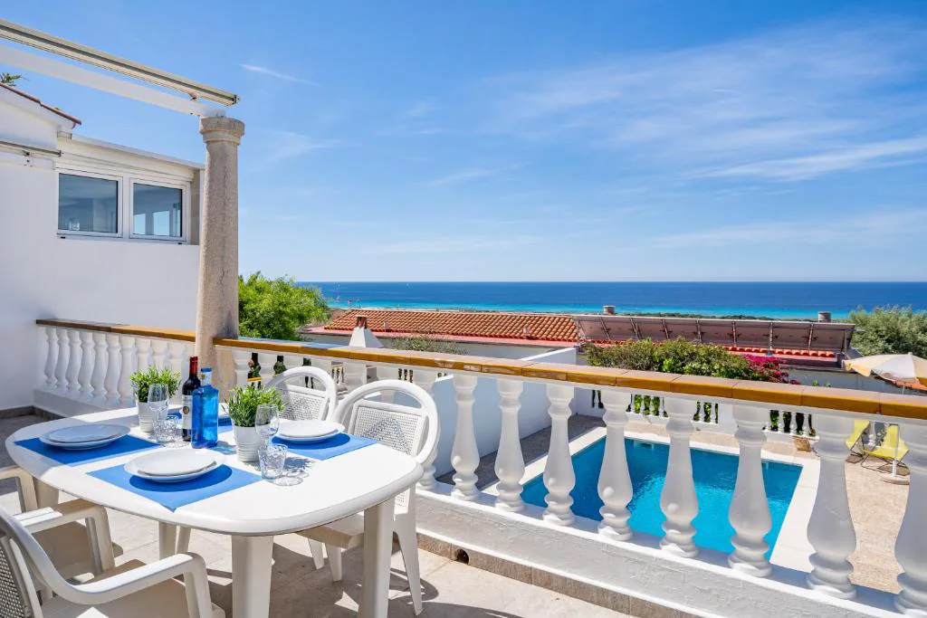 Balcón con mesa vestida y vistas directas al mar, Can Poriol, en Torre Solí Nou, Alaior, Menorca