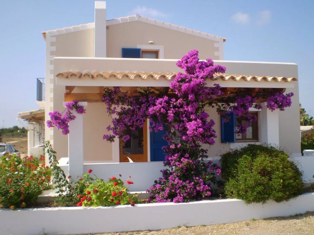 Fachada cubierta de buganvillas moradas de Can Vicent Sita, casa rural en Sant Francesc Xavier, Formentera