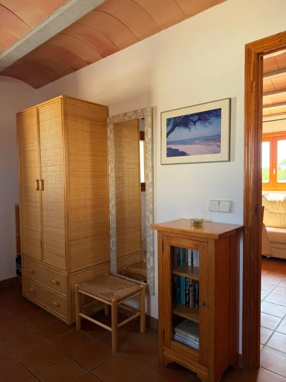 Dormitorio con armario de fibra natural y librería de madera, Can Vicent Sita