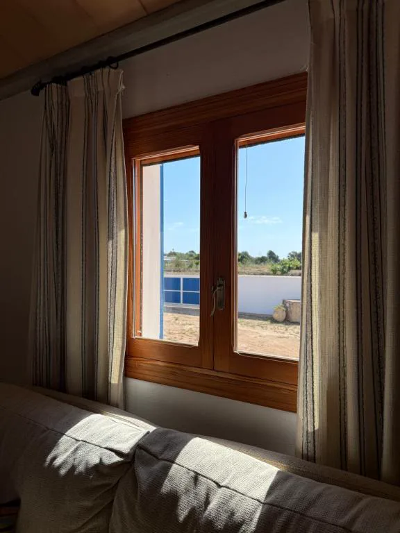 Ventana de madera con vistas al campo formenterense desde el salón, Can Vicent Sita