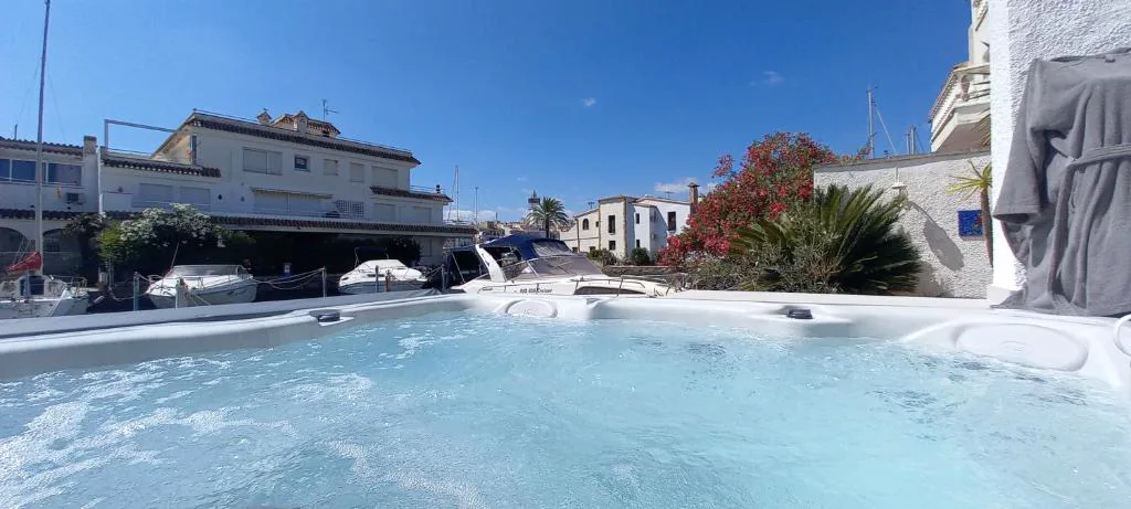 Jacuzzi exterior frente a casas blancas de la urbanización