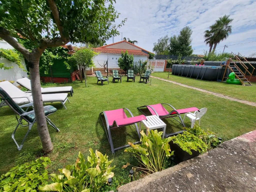 Jardín con tumbonas rosas y césped