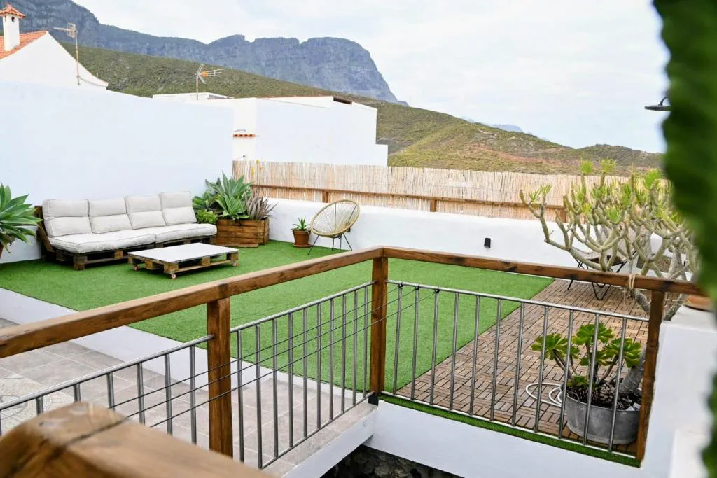 Azotea con sofá de palés, césped artificial y vistas a las montañas de Agaete, Casa Bailarina