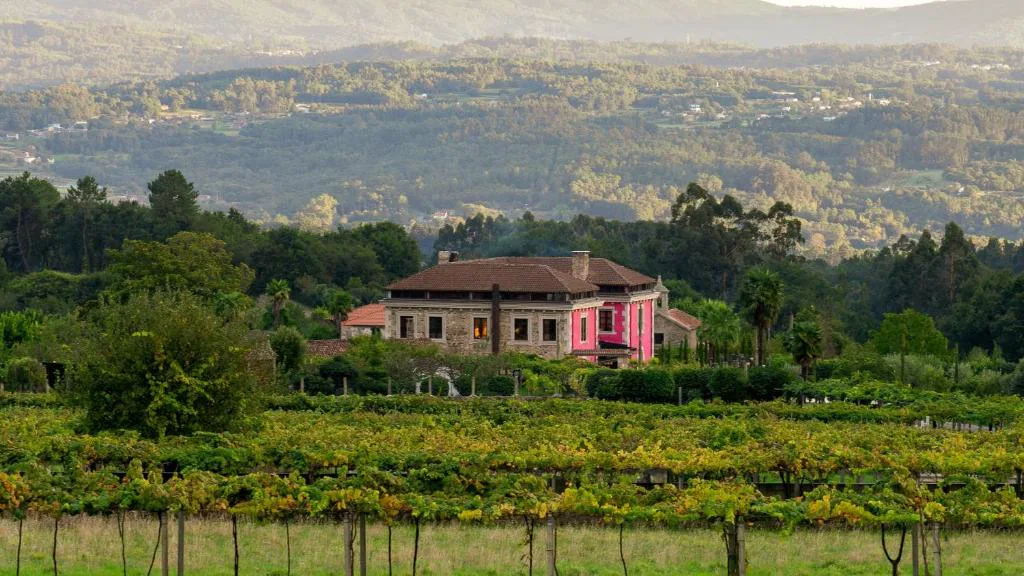 Fachada rosa de la casona del siglo XVIII entre viñedos de albariño, Casa Beatnik