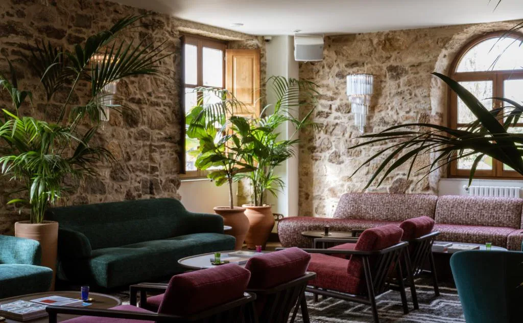 Salón con sofás y paredes de piedra vista, Casa Beatnik