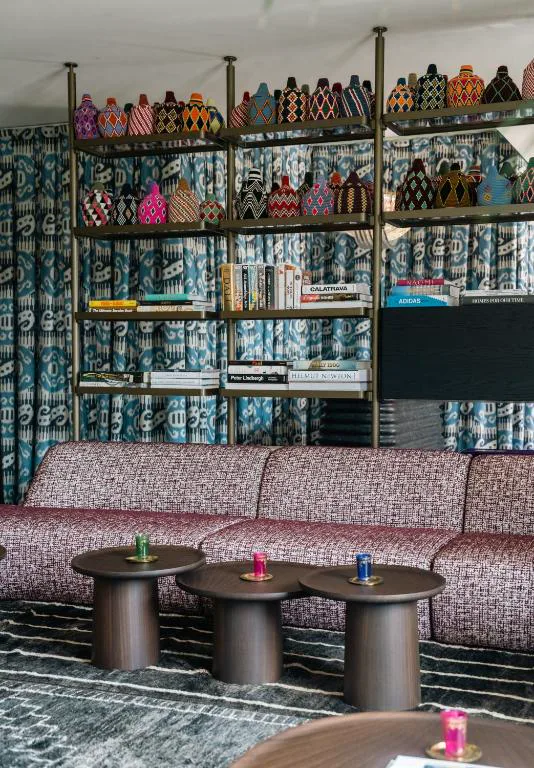 Zona de estar con decoración ecléctica y estanterías de libros y artesanía, Casa Beatnik