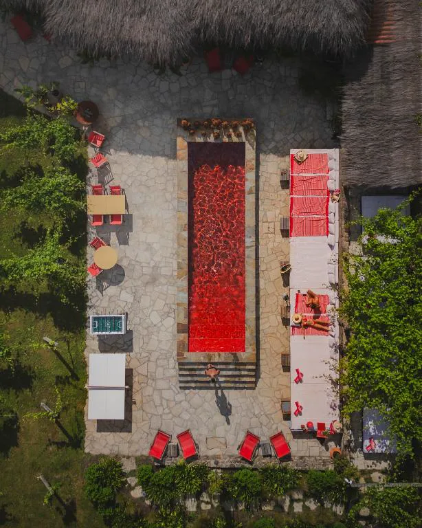 Vista aérea de la piscina de diseño retro rodeada de tumbonas rojas, Casa Beatnik Country House