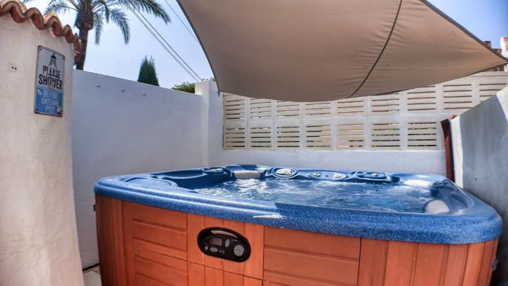 Jacuzzi con toldo en un patio blanco