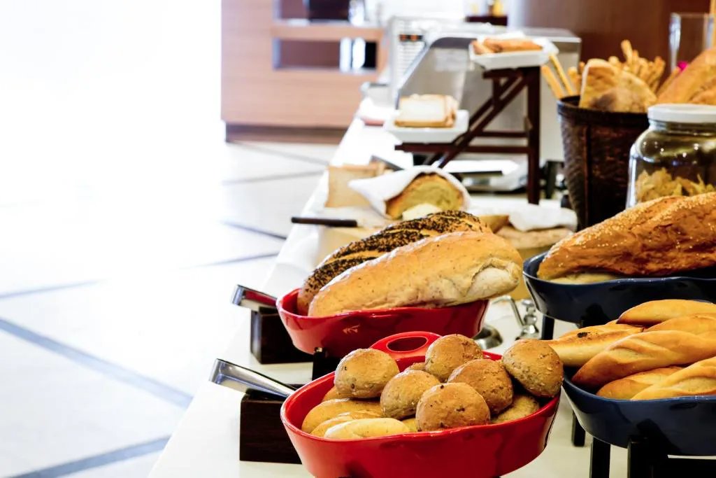 Mesa de desayuno con panes variados y cestas de bollería, Casa Buda Conors & Spa Boutique