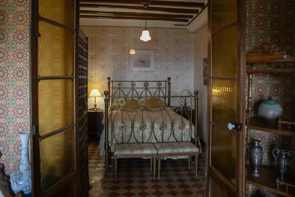 Habitación con cama de forja y vigas