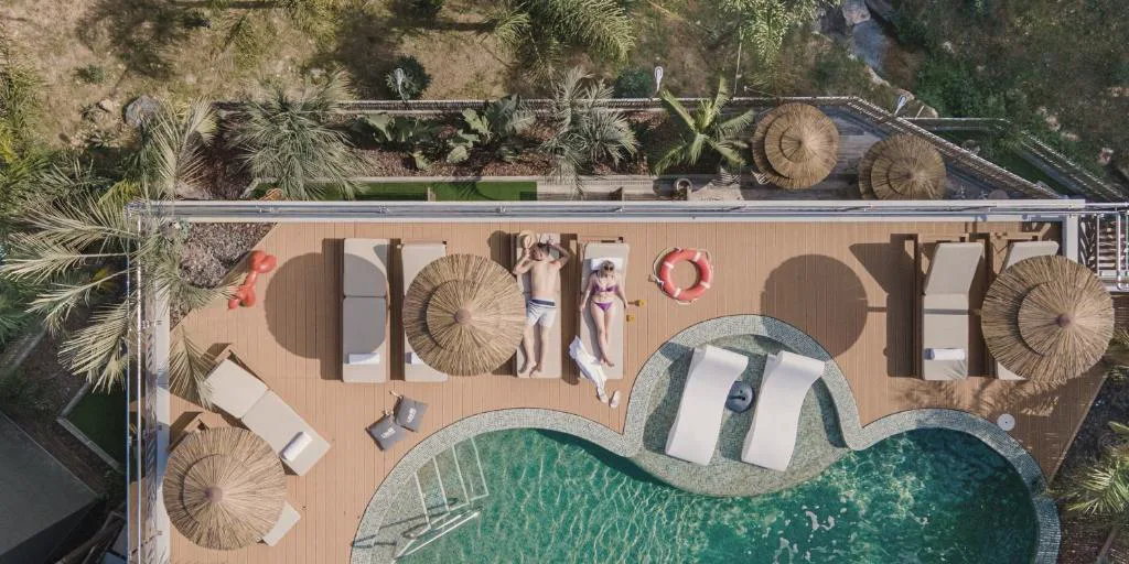 Vista aérea de la piscina con tumbonas y terraza