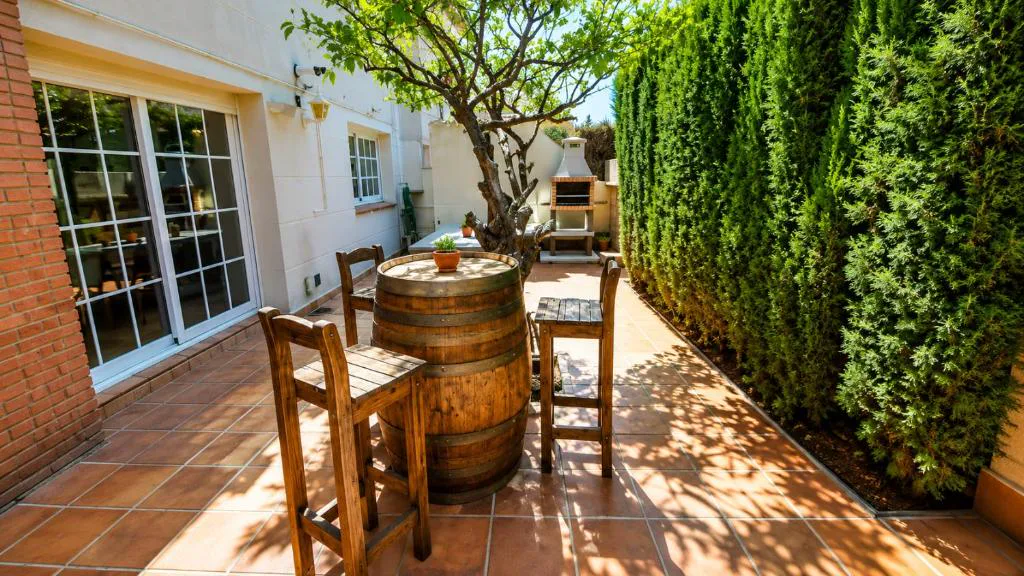 Comedor exterior con barril y sillas de madera